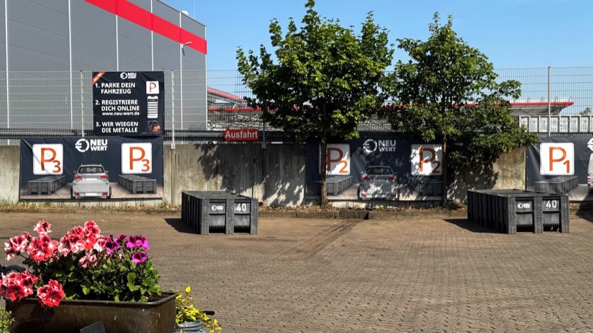 Der saubere NEUWERT-Hof mit den Parkboxen P1 bis P3 und dem Ablaufplan-Banner